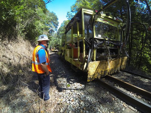 A group of people doing maintenance on a railroad.